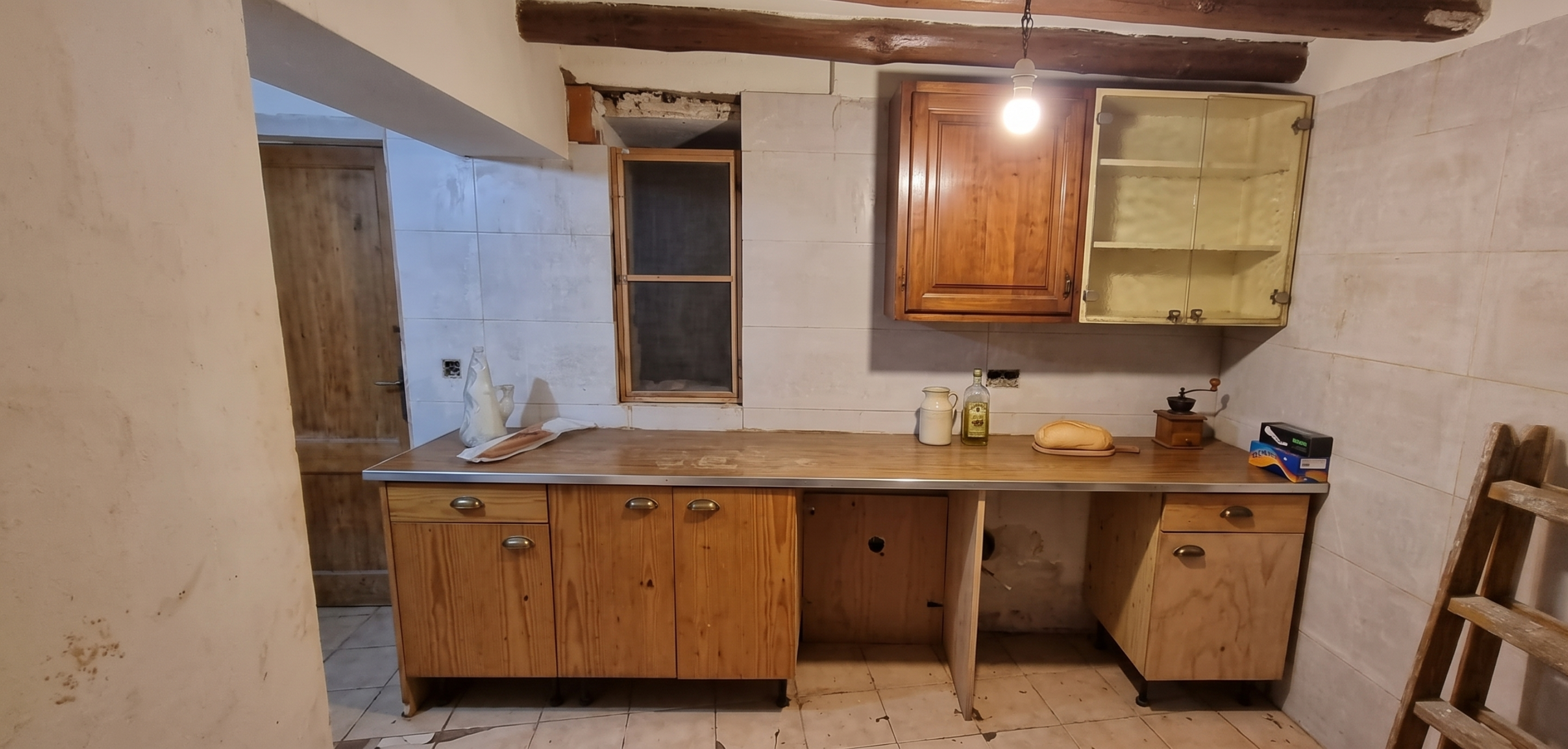 Cocina antes de la reforma con distribución antigua y mobiliario desgastado